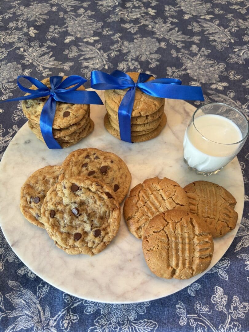 An assortment of cookies and a glass of milk on a marble platter.