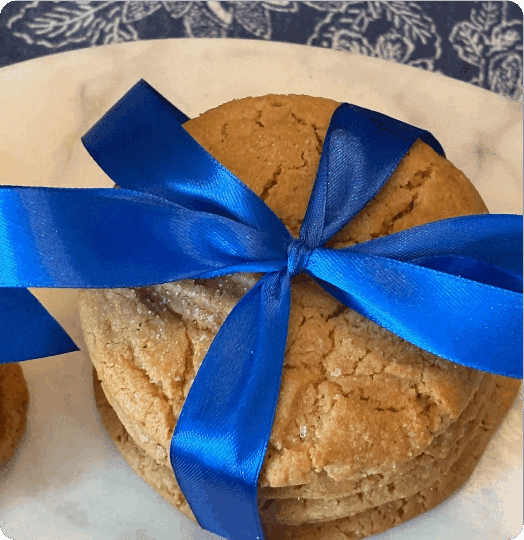 A stack of cookies tied with a blue ribbon on a plate.